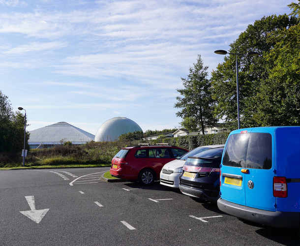 Four cars parked in car park bays with the Science Centre and Planetarium in the background