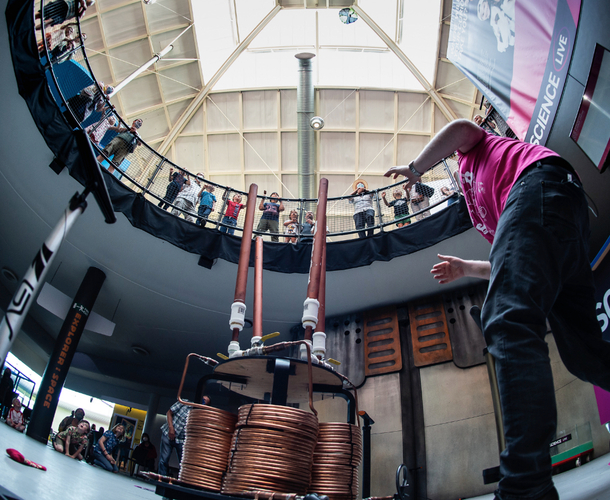 Live science demo area photo showing a presenter looking up to visitors on the balcony to see how far an object has flown into the air