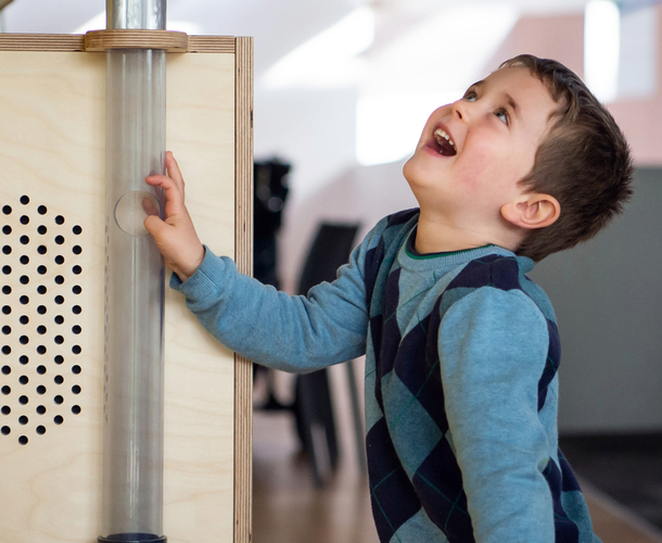 Young boy looking up in wonder while interacting with an exhibit