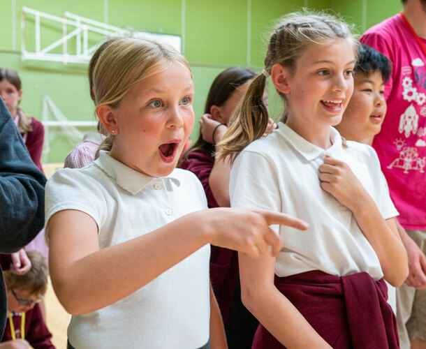 Two girls stare in amazement at something off camera