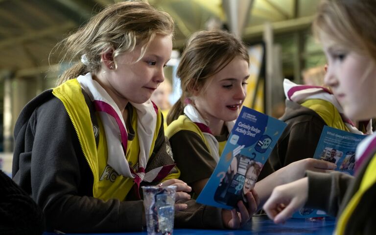 Two girls look at an activity book