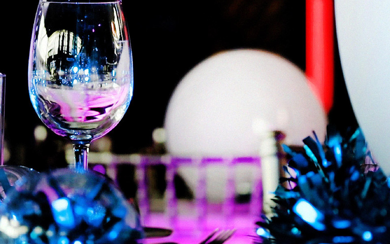 A wine glass on a festive dinner table