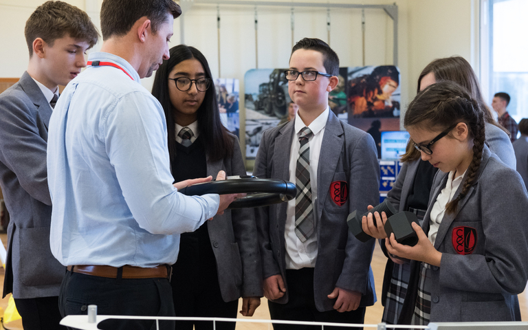 Students talk to a exhibitor at a science festival