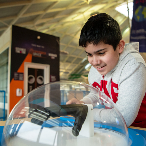 A boy plays with a prosthetic robot hand exhibit at Winchester Science Centre
