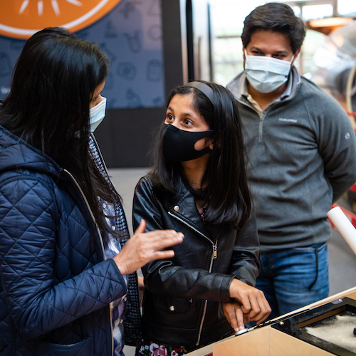 A girl and her parents wearing face masks