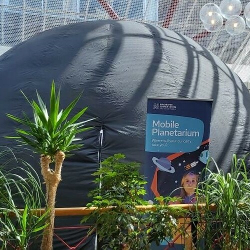 A mobile planetarium surrounded by plants