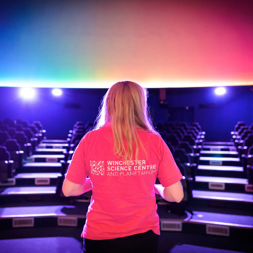 Planetarium photo showing a girl in a Winchester Science Centre polo shirt looking out at the auditorium