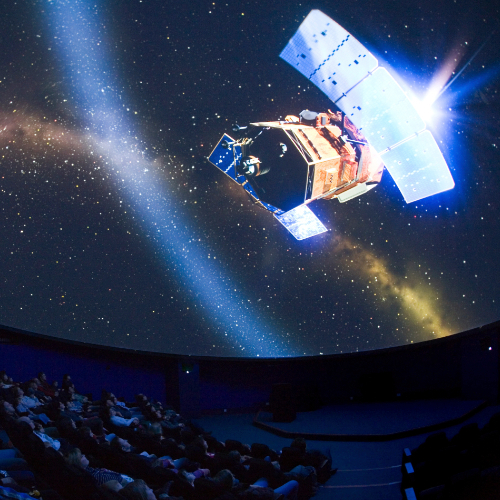 Planetarium photo showing an audience looking at the space station on the screen