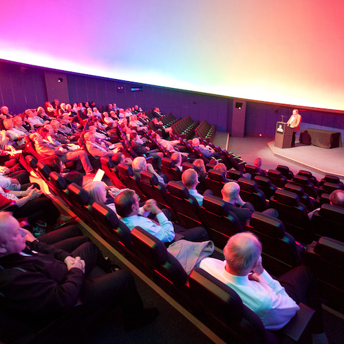 Planetarium photo showing an audience sitting in the auditorium listening to a speaker at the front