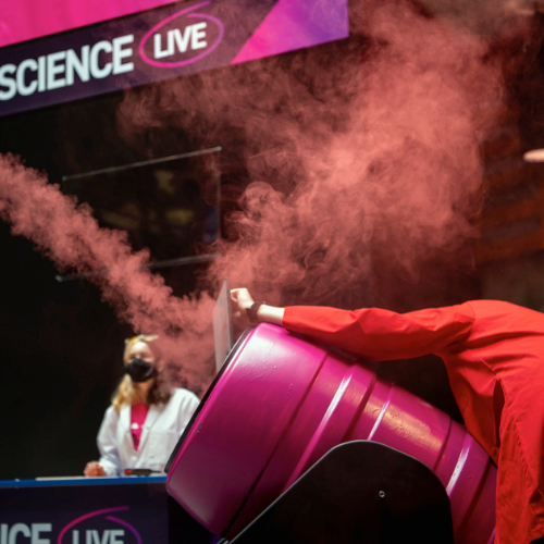 Live science demo area photo showing a presenter surrounded by red smoke