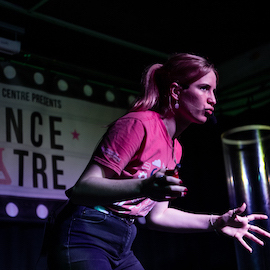 Live science show photo showing a female presenter gesturing with her hands to the audience