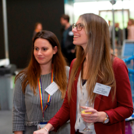 Interactive science exhibition photo showing two women smiling and looking at an exhibit