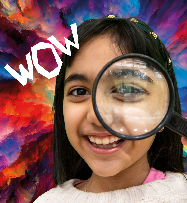 A girl hold a magnifying glass over her eye and smiles