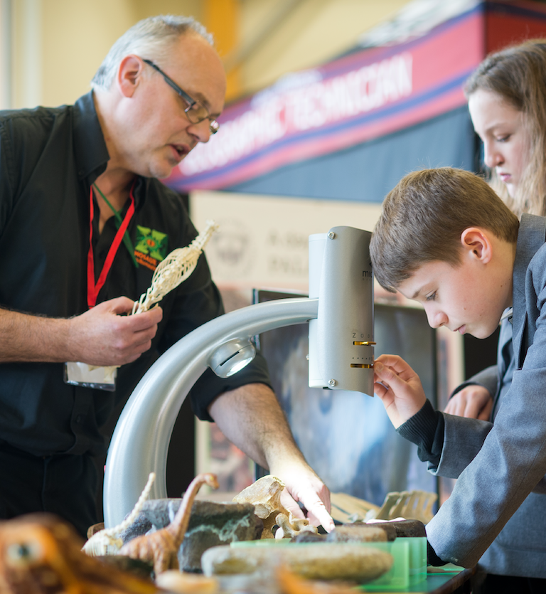 An exhibitor interacts with school pupils