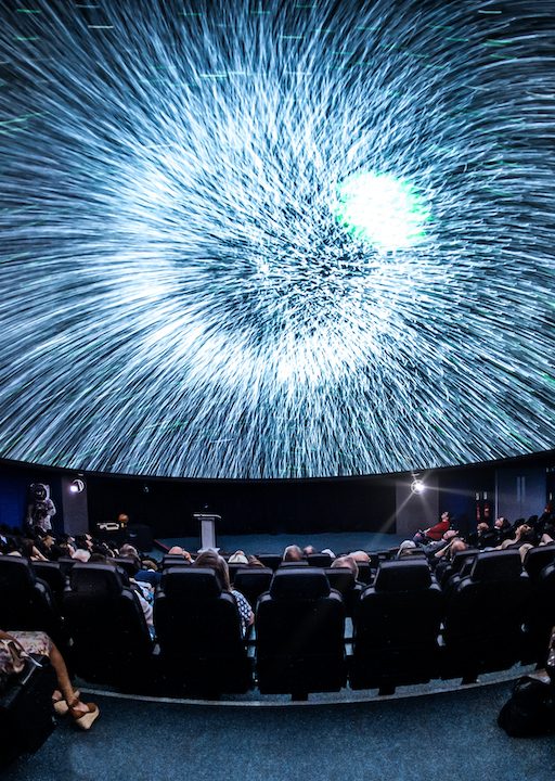 Planetarium photo showing an audience looking at stars on the screen