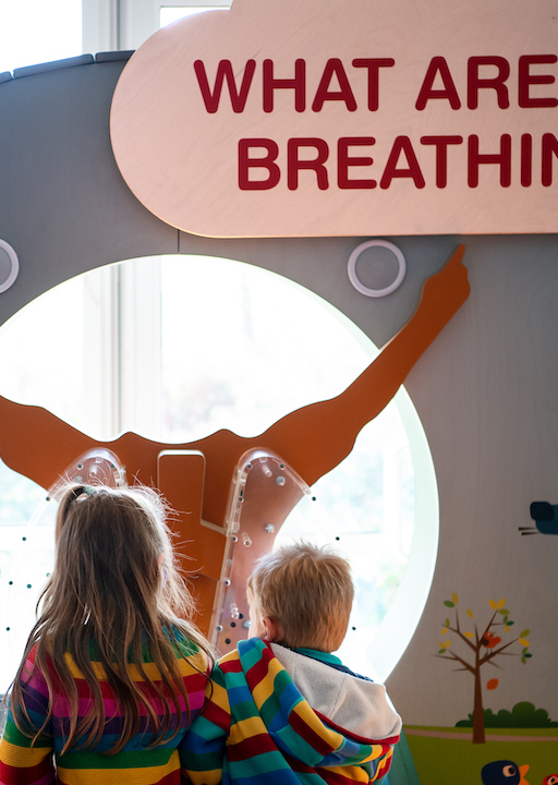 Interactive science exhibition photo showing two children engaging with an exhibit