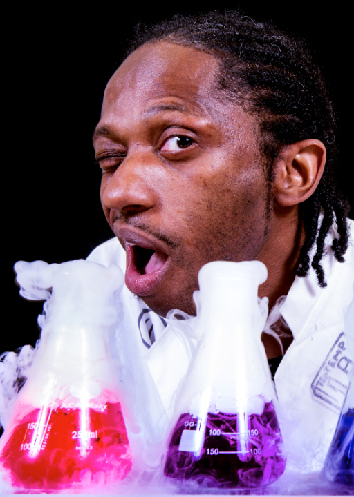 Live science show photo showing a science communicator looking at chemical reactions taking place in some beakers