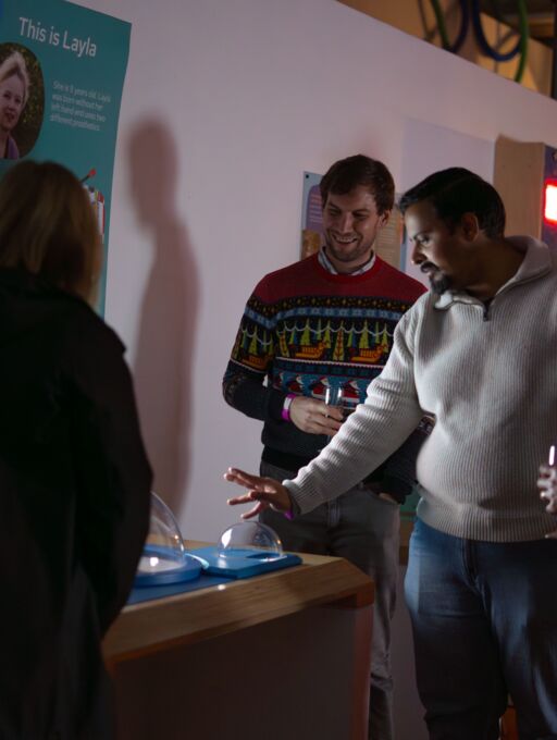 A woman laughs whilst interacting with a science exhibit
