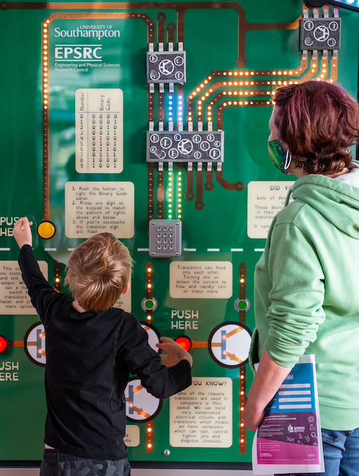 Interactive science exhibition photo showing two children engaging with an exhibit